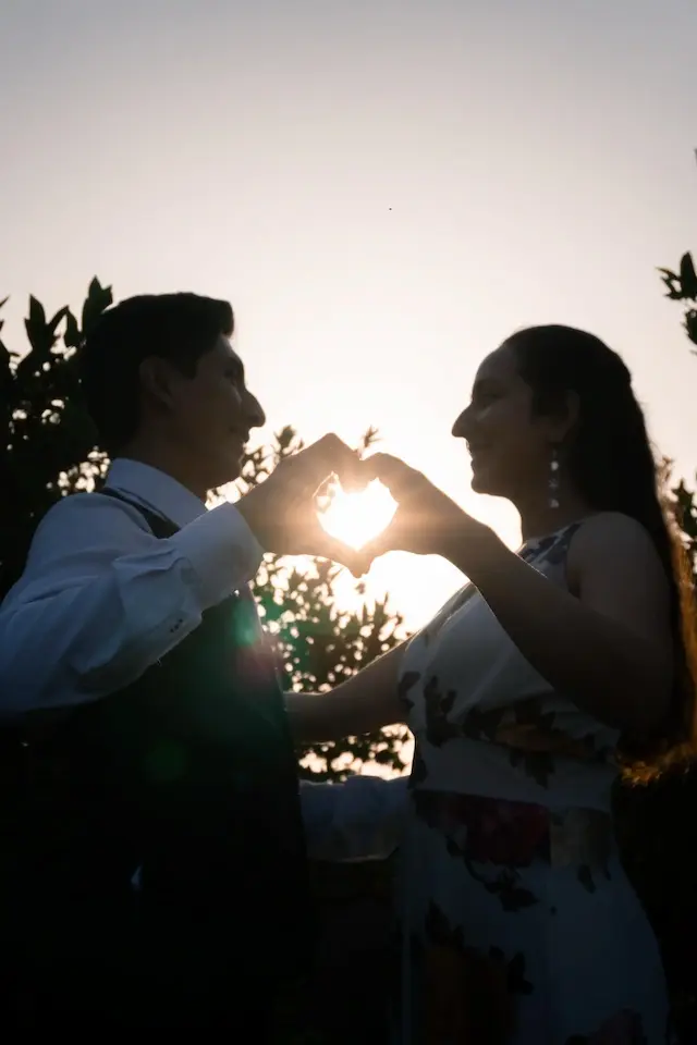 Pareja haciendo forma de corazón con sus manos
